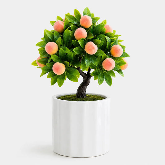 Artificial mini peach bonsai in a white ceramic planter.