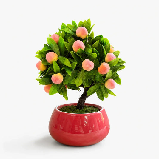 Artificial mini peach bonsai in a red ceramic planter.