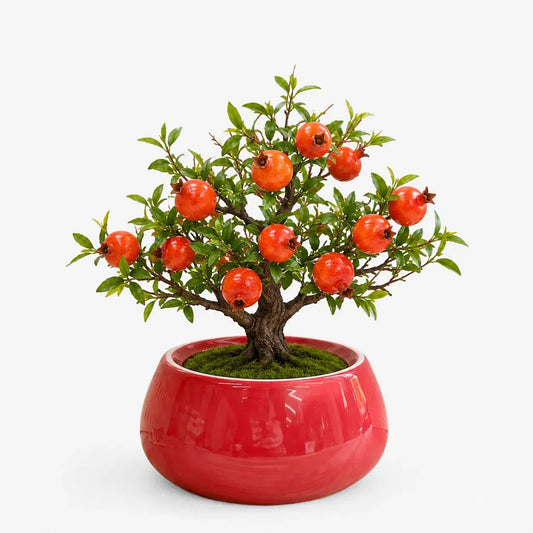 Artificial pomegranate bonsai in a red ceramic planter.