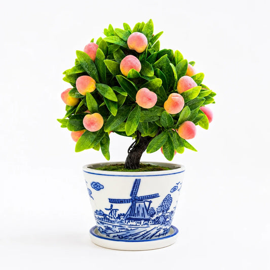 Artificial mini peach bonsai in a blue and white ceramic planter.